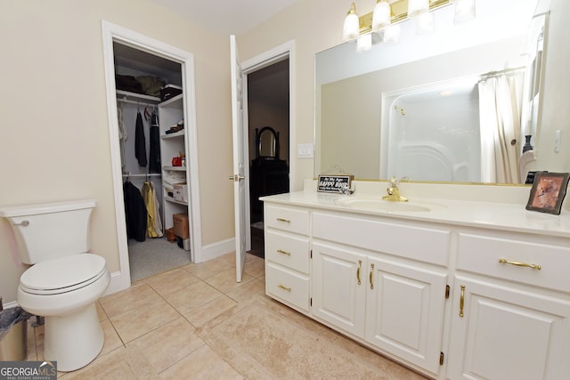 bathroom featuring tile patterned flooring, vanity, and toilet