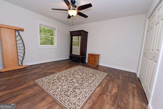 bedroom featuring ceiling fan, dark hardwood / wood-style floors, and a closet