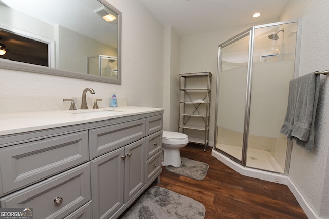 bathroom with hardwood / wood-style flooring, vanity, and a shower with shower door