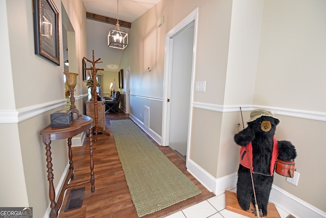 corridor featuring hardwood / wood-style flooring and a notable chandelier