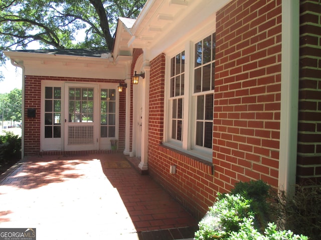 view of exterior entry with a patio area