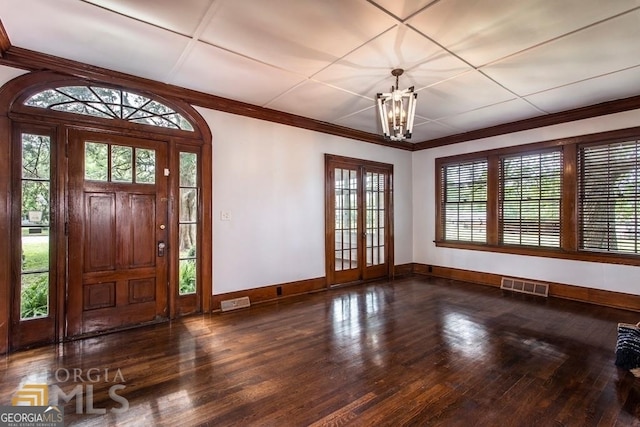 entrance foyer featuring a chandelier, dark hardwood / wood-style flooring, and crown molding