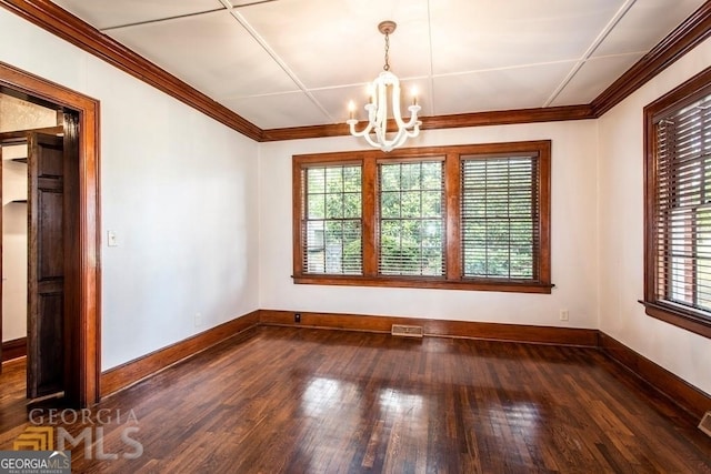 unfurnished dining area with dark hardwood / wood-style flooring, ornamental molding, and an inviting chandelier