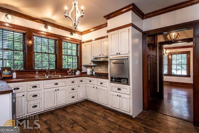 kitchen with decorative backsplash, dark hardwood / wood-style flooring, white cabinetry, and sink