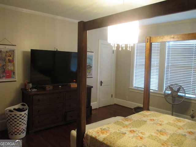 bedroom featuring crown molding, dark hardwood / wood-style flooring, and a notable chandelier