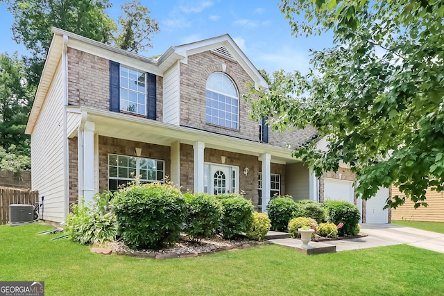 view of front of property featuring central air condition unit, a front lawn, covered porch, and a garage