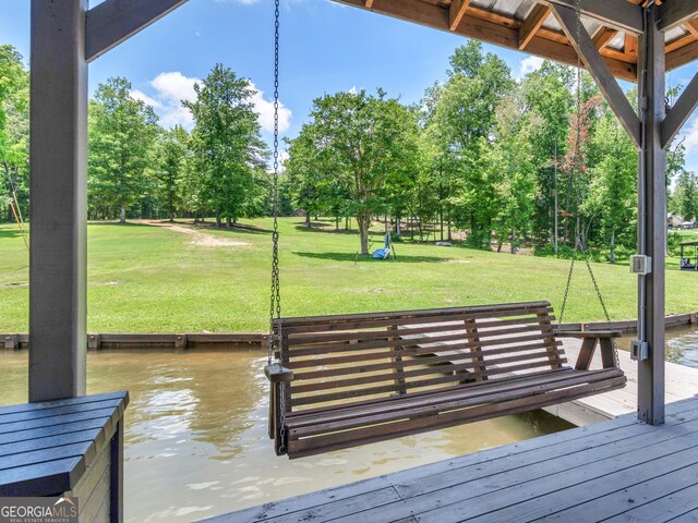 view of dock with a water view and a yard