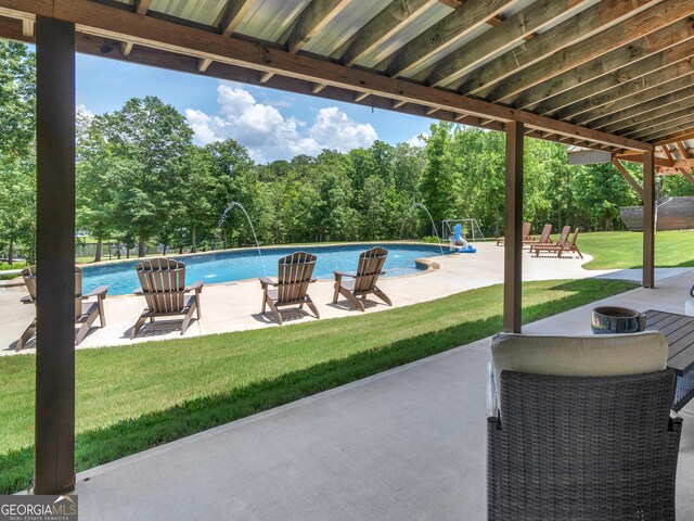 view of swimming pool featuring pool water feature, a yard, and a patio area