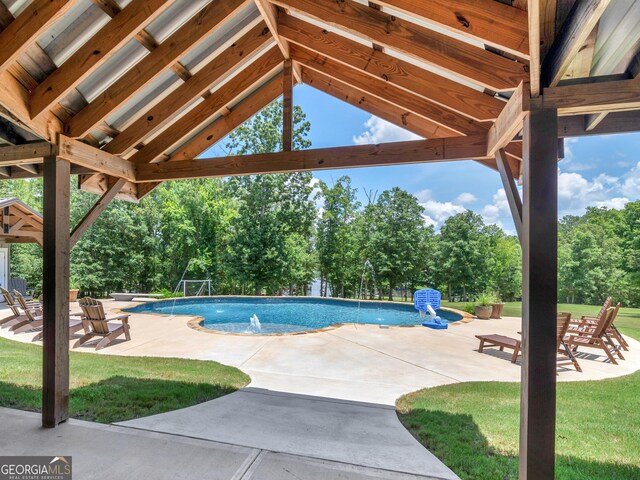 view of swimming pool featuring a patio, pool water feature, and a lawn