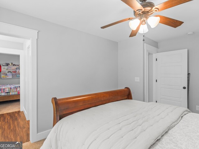 bedroom with ceiling fan and dark carpet