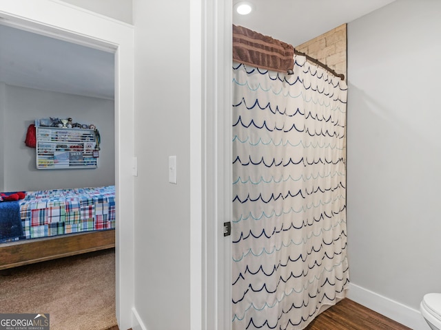 bathroom with toilet and hardwood / wood-style floors