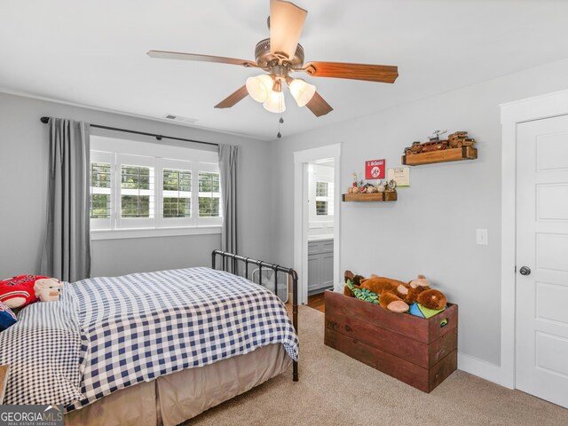 bedroom with ensuite bath, ceiling fan, and carpet flooring