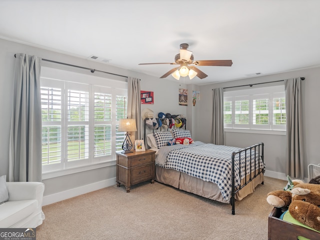 bedroom featuring multiple windows, ceiling fan, and light colored carpet