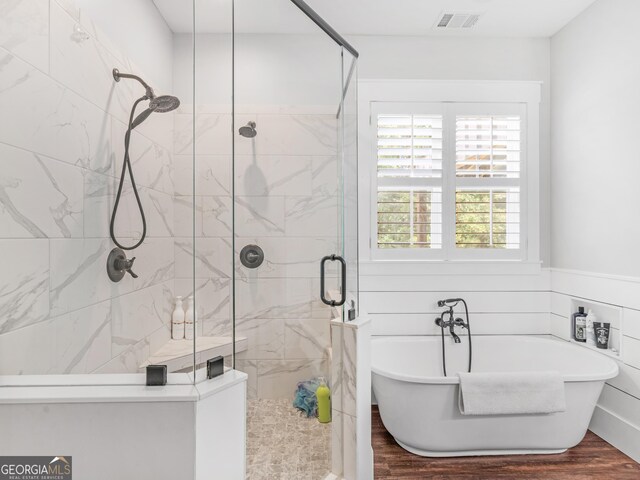 bathroom featuring separate shower and tub and hardwood / wood-style floors