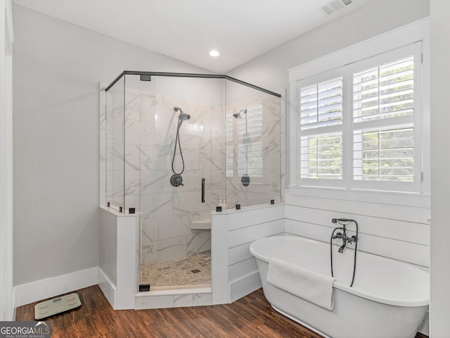 bathroom with independent shower and bath and hardwood / wood-style flooring