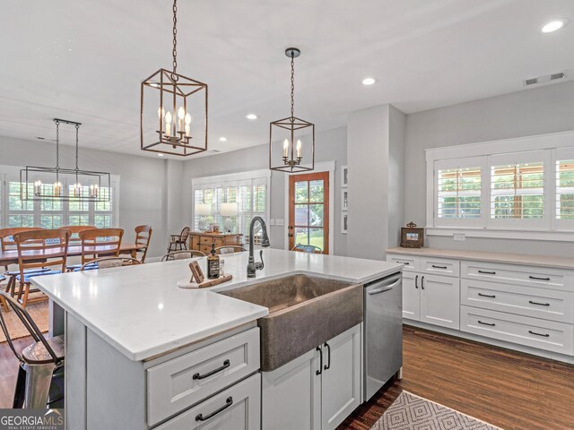 kitchen featuring dishwasher, a healthy amount of sunlight, and a kitchen island with sink