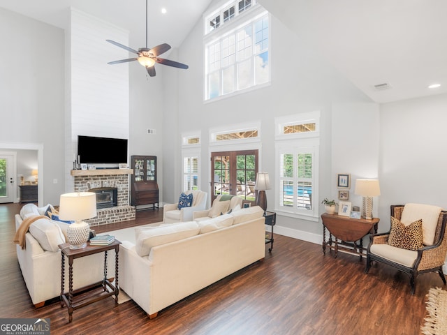 living room with high vaulted ceiling, a fireplace, ceiling fan, and dark hardwood / wood-style flooring