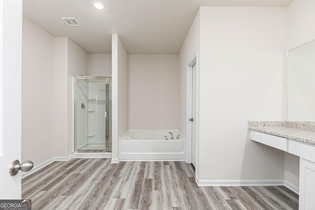 bathroom with vanity, wood-type flooring, and shower with separate bathtub