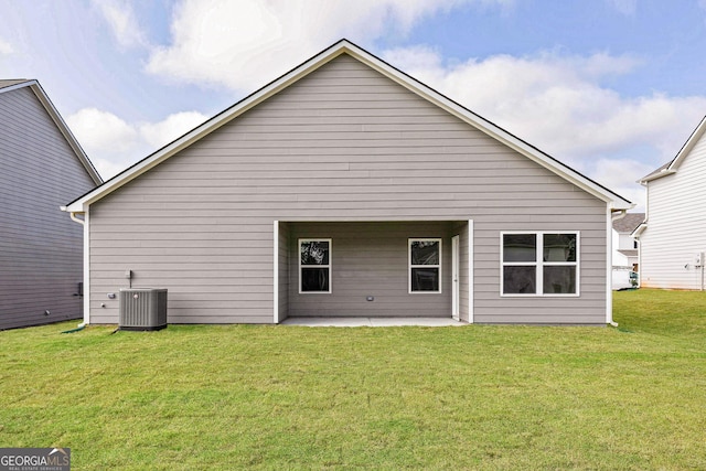 back of property featuring a lawn, cooling unit, and a patio