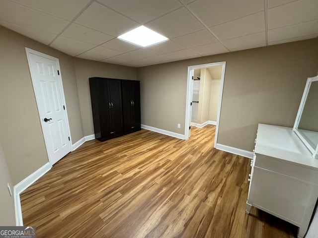 unfurnished bedroom featuring hardwood / wood-style floors and a drop ceiling