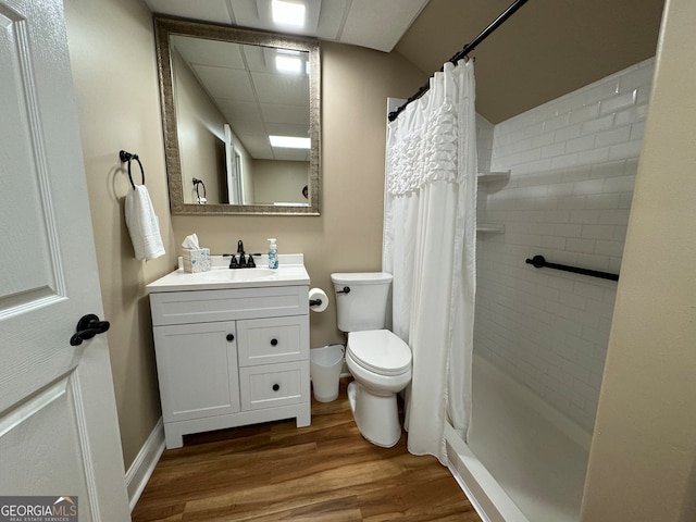 bathroom with a paneled ceiling, vanity, toilet, and hardwood / wood-style floors