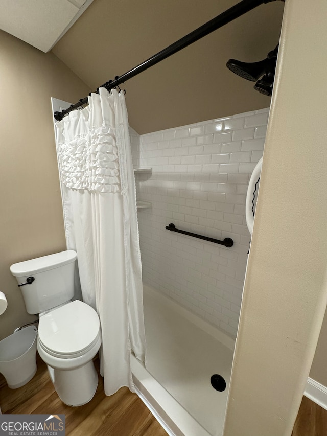 bathroom featuring a shower with shower curtain, toilet, and wood-type flooring