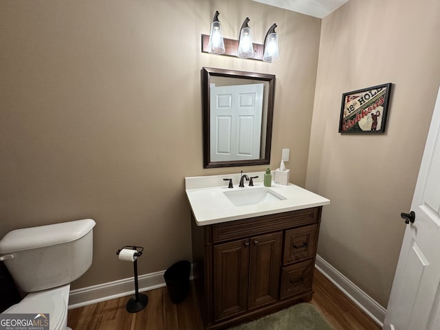 bathroom featuring hardwood / wood-style flooring, toilet, and vanity