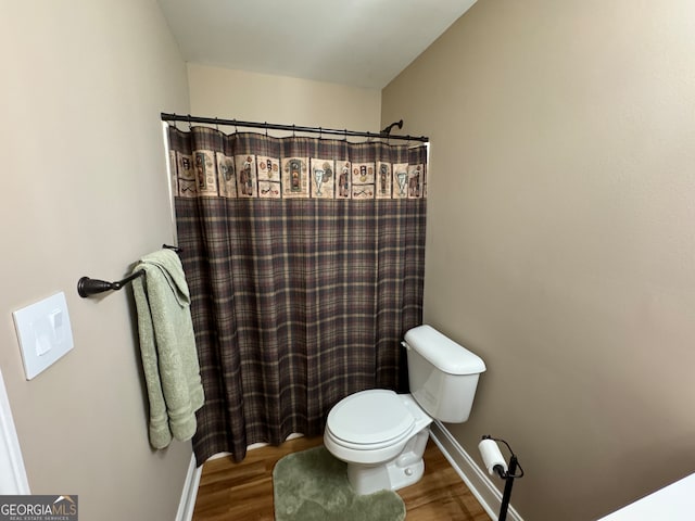 bathroom featuring wood-type flooring and toilet