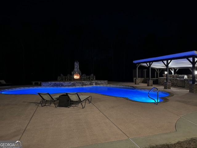 pool at night with a patio area