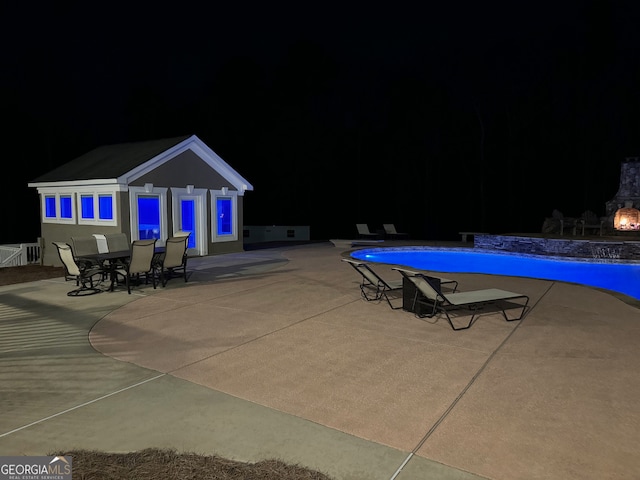 pool at night with a patio area