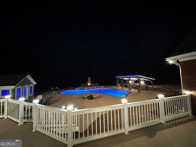 pool at twilight with a patio area