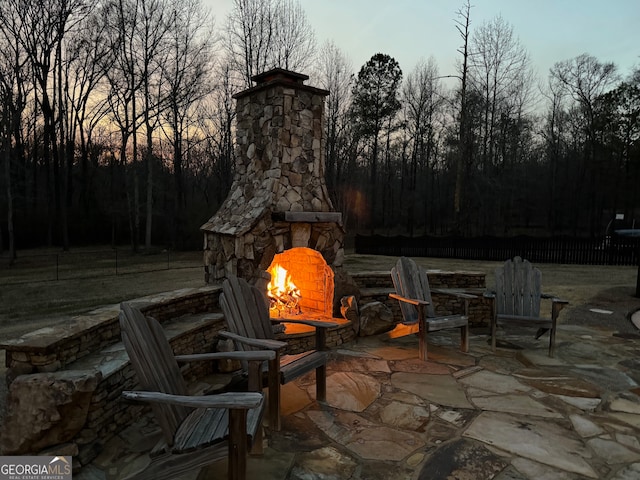 patio terrace at dusk with an outdoor stone fireplace