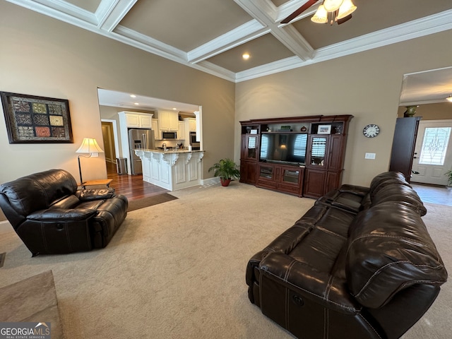 carpeted living room with ceiling fan, coffered ceiling, beam ceiling, and ornamental molding