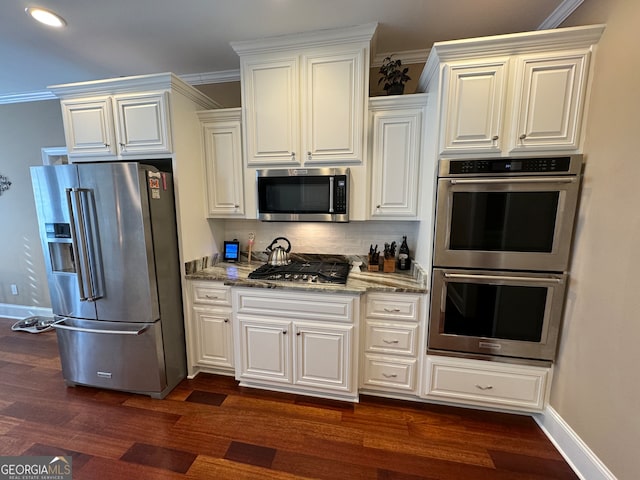 kitchen featuring ornamental molding, dark hardwood / wood-style flooring, stone countertops, and appliances with stainless steel finishes