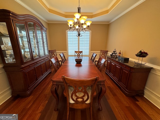 dining area featuring a chandelier, dark wood-type flooring, and a raised ceiling