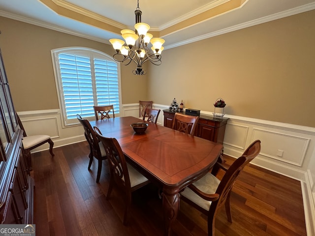 dining space featuring an inviting chandelier, a raised ceiling, and dark hardwood / wood-style flooring