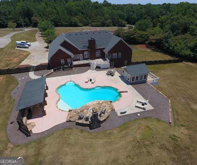 view of pool with a patio area and a yard