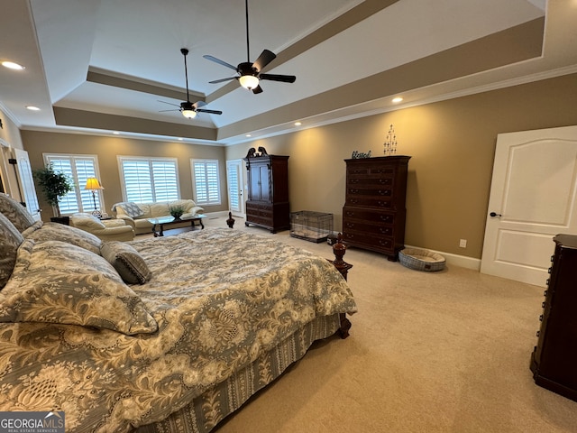 bedroom with a tray ceiling, crown molding, ceiling fan, and light colored carpet