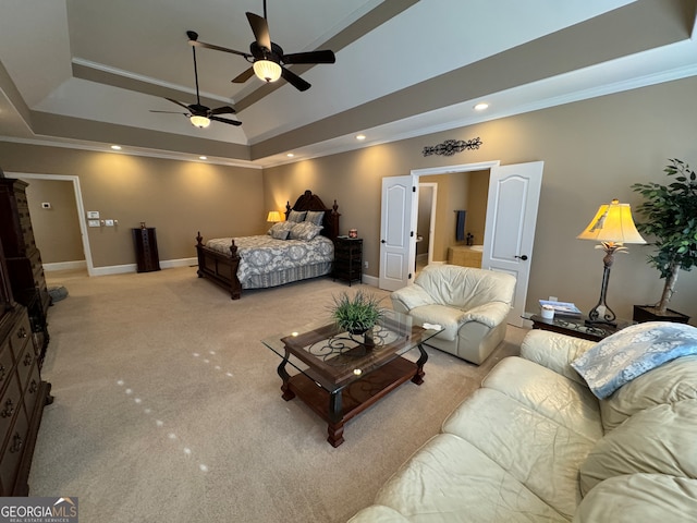 living room featuring ceiling fan, a tray ceiling, carpet flooring, and ornamental molding