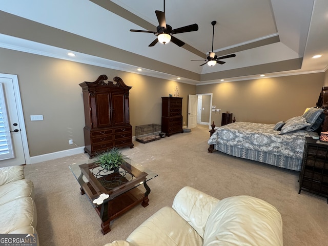 carpeted bedroom with ceiling fan and a tray ceiling