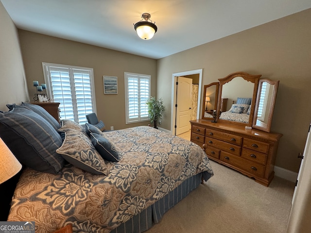 carpeted bedroom featuring ensuite bath