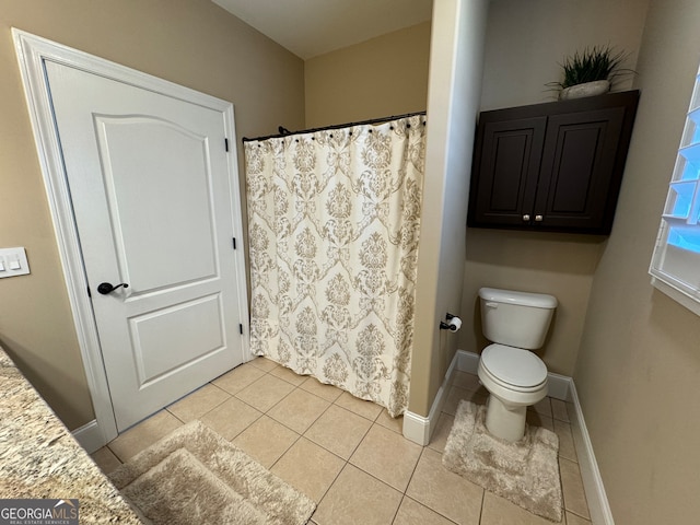 bathroom with tile floors, vanity, and toilet