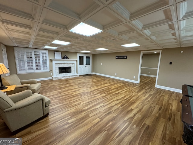 living room featuring a stone fireplace and wood-type flooring