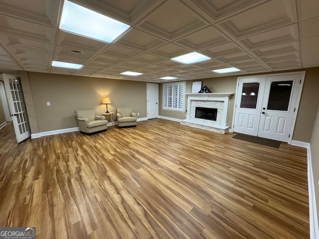 unfurnished living room with french doors, a fireplace, and wood-type flooring