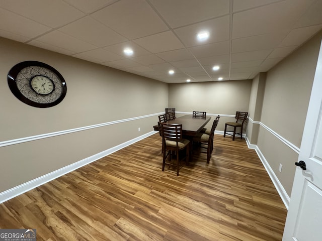 dining space featuring hardwood / wood-style floors and a drop ceiling