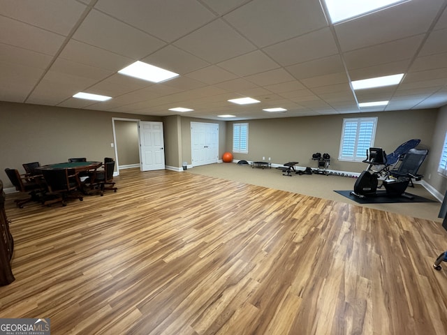 workout area featuring wood-type flooring and a drop ceiling