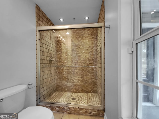 bathroom featuring toilet, tile patterned flooring, and walk in shower