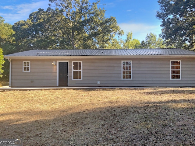 back of house featuring a lawn