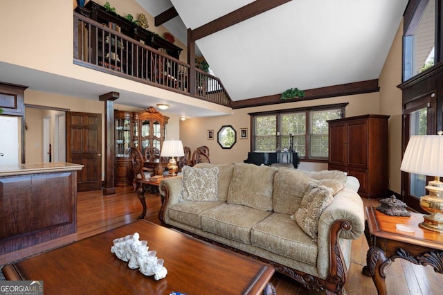 living room with high vaulted ceiling, plenty of natural light, and wood-type flooring