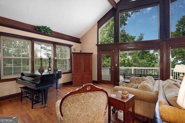 living area with plenty of natural light, light hardwood / wood-style flooring, and high vaulted ceiling